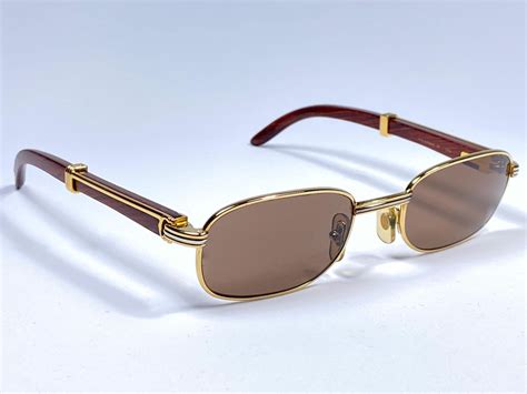 <b>Sunglasses</b> in white horn with a smooth golden finish, rectangular shape, green lenses and class 3 solar protection. . Cartier wood glasses